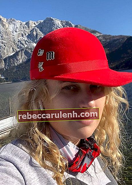 Ребел Уилсон в красной кепке и показывает значки в 2020 году