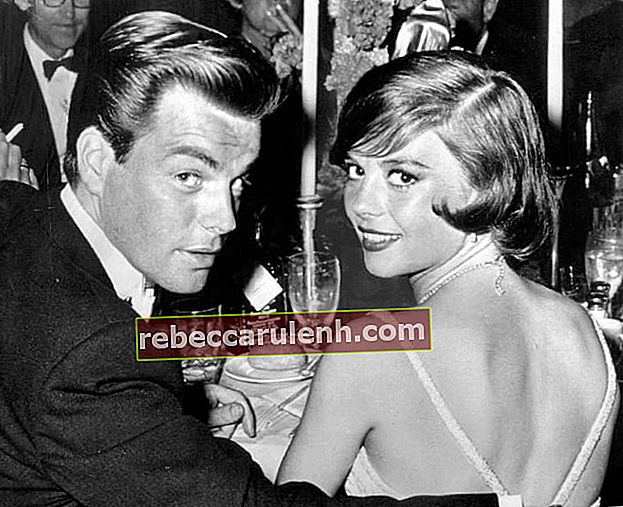 Натали Ууд се усмихва за снимка заедно със съпруга си Робърт Вагнер на вечерята на наградите "Оскар" през 1960 г.