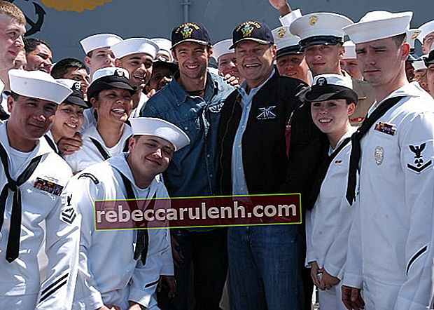 Келси Грэммер (в центре справа) и Хью Джекман (в центре слева) позируют с членами экипажа на летной палубе на борту десантного корабля USS Kearsarge (LHD 3) в мае 2006 года.