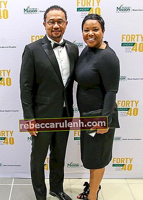 Kellie Shanygne Williams en souriant devant la caméra aux côtés de son mari lors de l'événement Black Alumni Forty Under 40 de l'Université George Mason en octobre 2019