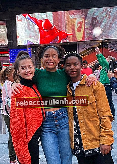 Kai Calhoun en souriant sur une photo avec Symera Jackson (au centre) et Eliza Pryor à Times Square, New York City, New York en octobre 2019
